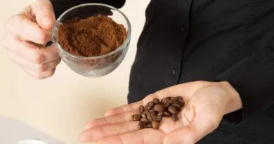 Como moer café - Na imagem uma pessoa segurando em uma mão uma xicara com café moido e na outra um punhado de grãos de café sem moer.